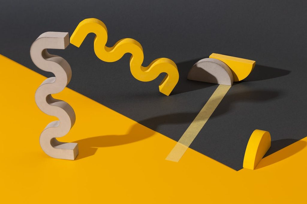Modern composition of yellow and gray geometric shapes on contrasting backdrop.