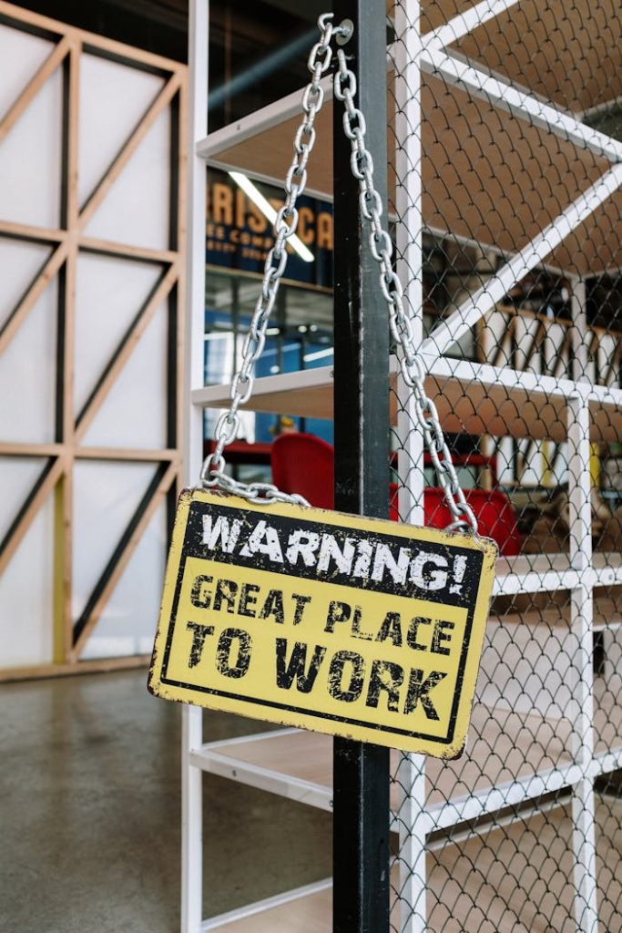 Industrial style office interior with amusing warning sign, showcasing a creative workspace.